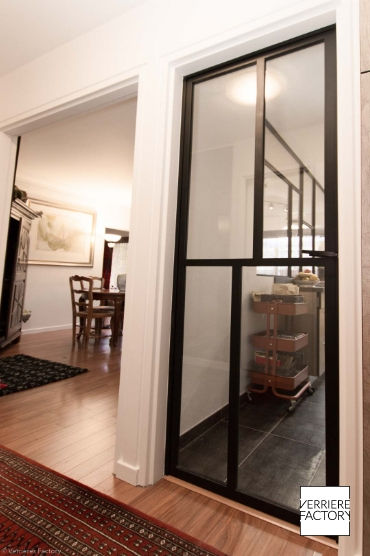 Porte verrière mondrian séparant la cuisine du couloir.